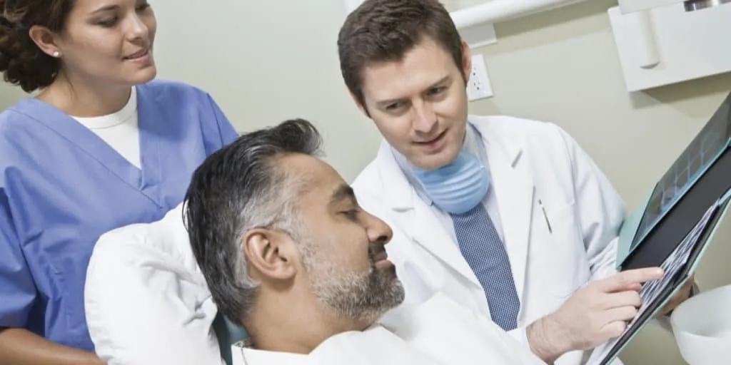 Dentist discussing root canal treatment to patient.