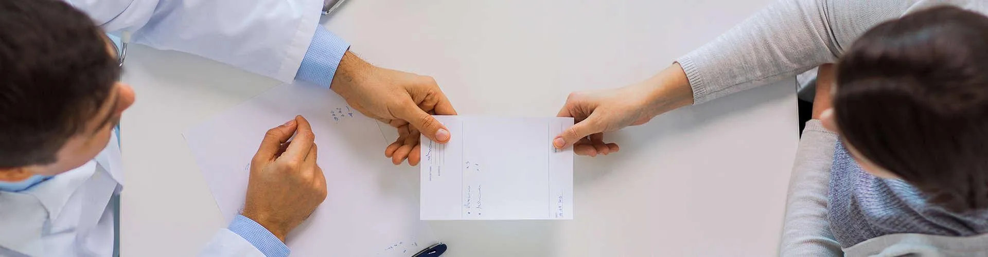 Dentist accepting referral form from new patient.