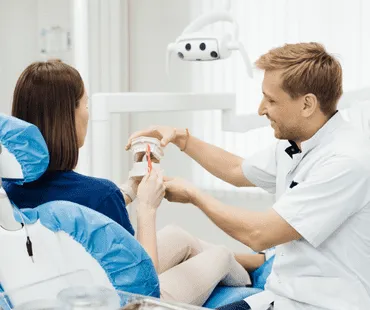Dentist showing the correct dental hygiene on female patient.